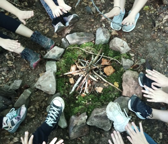 Kinderhände an einer Feuerstelle